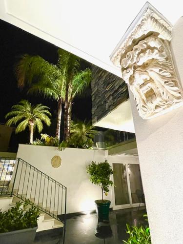 a house with palm trees on the side of it at Dimora dei lidi in Fontane Bianche