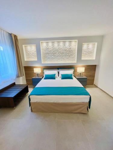 a bedroom with a large bed with blue pillows at Dimora dei lidi in Fontane Bianche