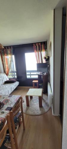 une pièce avec un lit et une table dedans dans l'établissement Appartement montagne, à Superbagnères