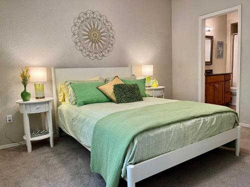 a bedroom with a large bed with green sheets and pillows at Gated Condo Heated Pool Spa Gym Near Zoo in Phoenix