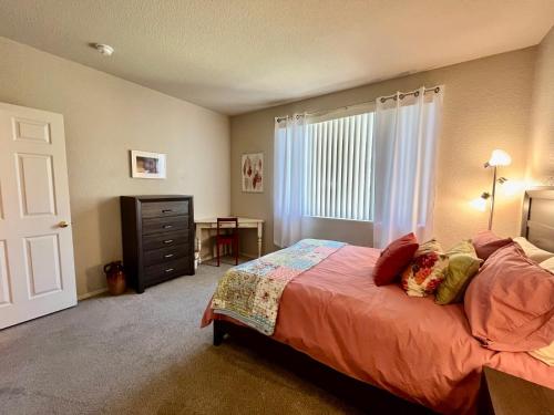 a bedroom with a bed and a dresser and a window at Gated Condo Heated Pool Spa Gym Near Zoo in Phoenix