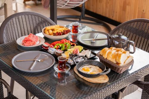 a table with a breakfast of eggs bread and fruit at Karaöz Sapphire Bungalows in Kumluca