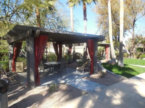 a pavilion with a table and chairs and palm trees at Gated Condo Heated Pool Putt Green Near Papago in Phoenix