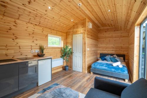 Habitación con cama en una cabaña de madera en The Lodge at The Outside Inn, en Mountfield