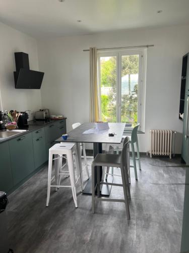 une cuisine avec une table et des chaises dans une cuisine dans l'établissement L'Eglantine bord de mer, à Ault