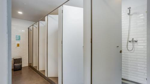 a walk in shower in a bathroom with white walls at Hostellicious in Faro
