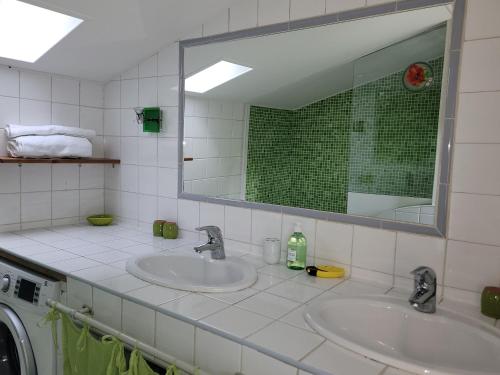 a bathroom with two sinks and a mirror at La tour de guet Maison atypique in Castellane