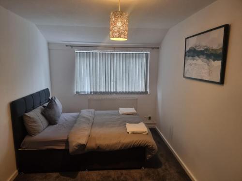 een slaapkamer met een bed in een kamer met een raam bij Rehoboth Living in Thamesmead