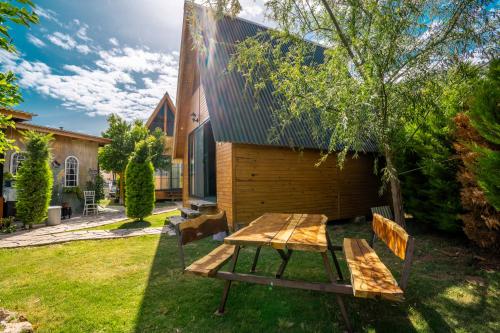 a picnic table and bench in front of a house at Karaöz Sapphire Bungalows in Kumluca