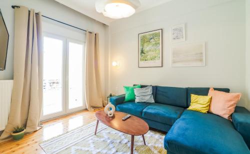 a living room with a blue couch and a table at Mazi Rooms Giannitsa in Giannitsa