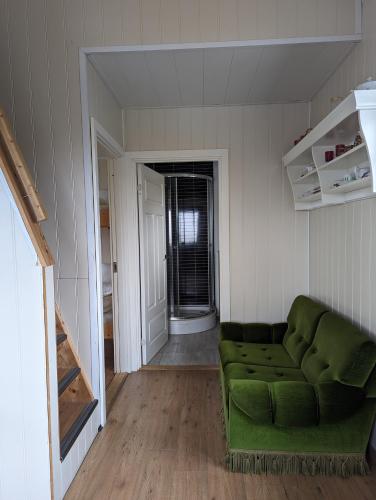 a living room with a green couch in a room at Vík Hostel in Vík