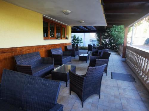 eine Restaurantterrasse mit Stühlen, Tischen und einem Fenster in der Unterkunft Hotel Prestige 3 Stars in Rimini