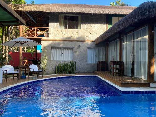 una piscina frente a una casa en Pousada Casa de Sapê, en Arraial d'Ajuda