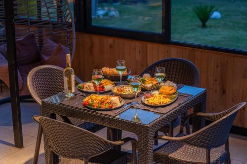 a table with plates of food and glasses of wine at Karaöz Sapphire Bungalows in Kumluca