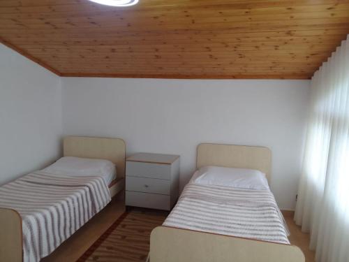 Duas camas num quarto com tecto em madeira em Akid&Alan Apartment em Tirana