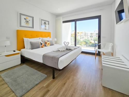 Un dormitorio con una cama grande y una ventana grande en Apartment Praia Rocha Residence Honey Glow, en Portimão