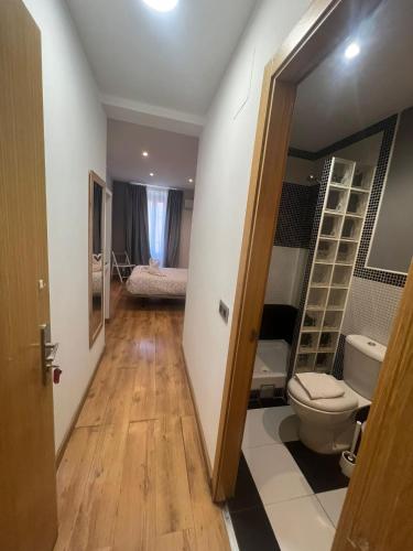 a bathroom with a toilet and a bed in a room at Hostal New Life Madrid in Madrid