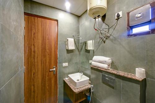 a bathroom with a sink and a mirror at Wood Rose Hotel Near Delhi Airport in New Delhi