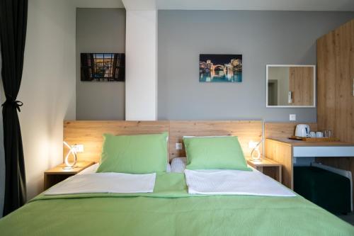 Imperial rooms في موستار: غرفة نوم بسرير اخضر ومصباحين