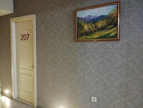 a painting hanging on a wall next to a door at Гостиница Низами Стрит in Baku