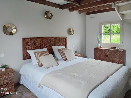 un grand lit blanc dans une chambre avec une fenêtre dans l'établissement Le Clos de la Rose gite bien être, à Wirwignes