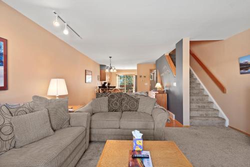 a living room with a couch and a staircase at Lagoon 723D by Great Western Lodging in Frisco