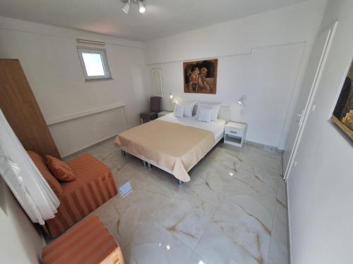 a white bedroom with a bed and a couch at Apartman Graciela Perfect location Gradac in Gradac
