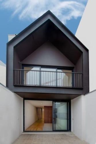 a building with a balcony on top of it at Casa da Beira Mar in Aveiro