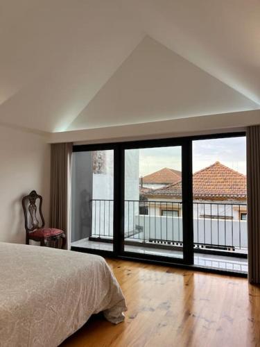 ein Schlafzimmer mit einem Bett und einem großen Fenster in der Unterkunft Casa da Beira Mar in Aveiro
