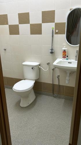 een badkamer met een toilet en een wastafel bij Kembara Homestay Four Room in Alor Setar