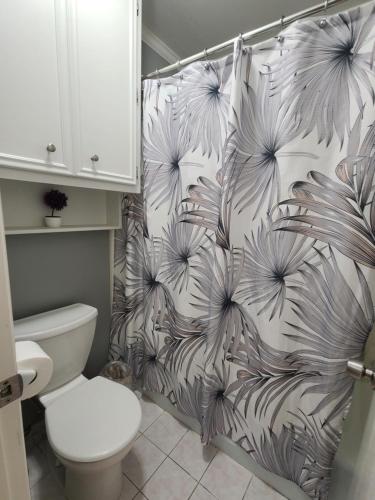 a bathroom with a white toilet and a shower curtain at 1976HoustonGem Luminous PvTPool & HotTub DT20mins for LRG Families 6Beds 2Bath in Houston