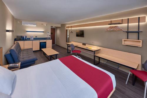 a hotel room with a large bed and a desk at City Express by Marriott Rosarito in Rosarito