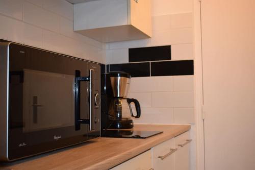 - un comptoir de cuisine avec une cafetière et un four micro-ondes dans l'établissement Studio au centre ville de Concarneau, à Concarneau