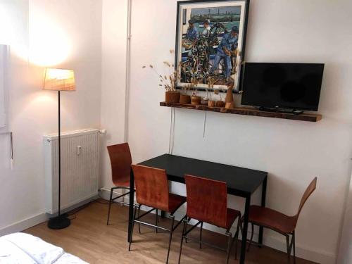 une salle à manger avec une table et des chaises et une télévision dans l'établissement Studio au centre ville de Concarneau, à Concarneau