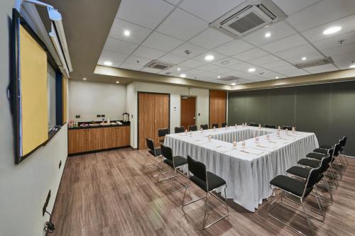 a conference room with a large white table and chairs at City Express by Marriott Rosarito in Rosarito