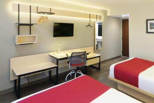 a hotel room with a desk and a bed at City Express by Marriott Rosarito in Rosarito
