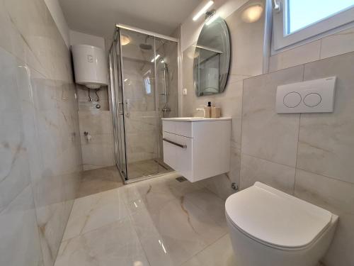 bagno bianco con servizi igienici e doccia di Apartman Graciela Perfect location Gradac a Gradac (Grado)