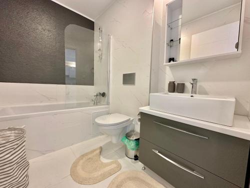 een witte badkamer met een wastafel, een toilet en een bad bij Double Studio B105 StayInn by Cosmopolis in Creţuleasca