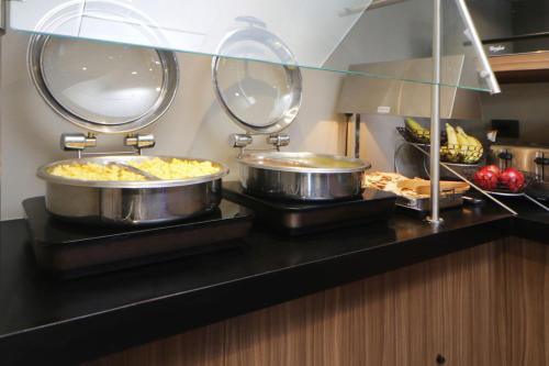 a buffet with two pans of food on a counter at City Express by Marriott Rosarito in Rosarito
