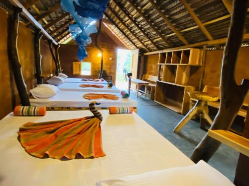 a group of four beds in a room at Yala Village Eco Tree House in Tissamaharama
