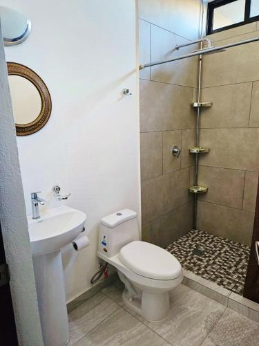 a bathroom with a shower and a toilet and a sink at Marina Cerritos Coral del Mar - 4 Albercas de Lujo - 1 Min Playas in Mazatlán