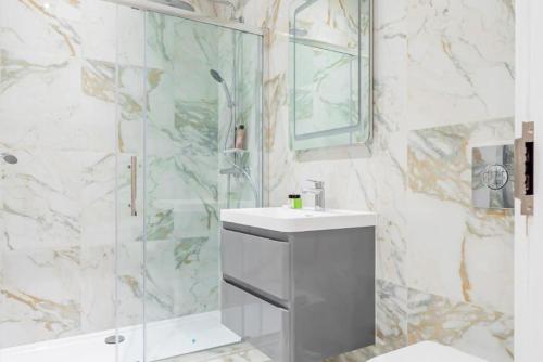 een badkamer met een douche, een wastafel en een spiegel bij High-end Stylish Apartments - **CENTRALLY LOCATED** in Reading