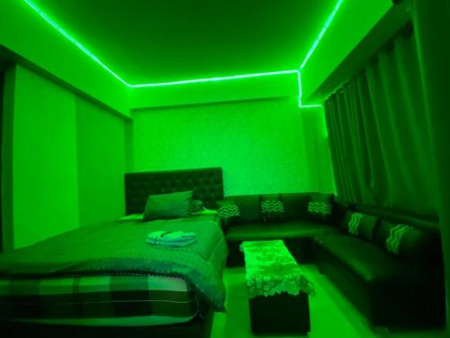 uma sala verde com um sofá e um tecto verde em APARTEMEN MARGONDA RESIDENCE 3 DEPOK By DBancah Rooms 719 em Kemirimuka Tiga