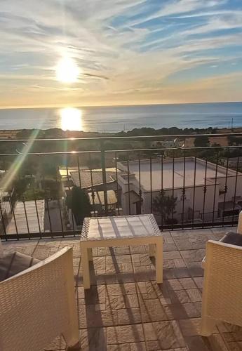 a table and chairs on a balcony with the ocean at Alykè Appartamenti Vacanze Macari in Macari
