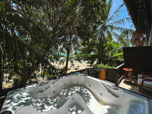 a jacuzzi tub on a patio with a beach at Vila Torém in Icaraí