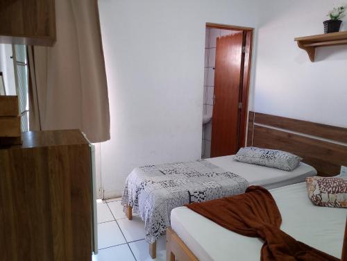 Habitación pequeña con 2 camas y ventana en Hotel Portal dos anjos en Aparecida