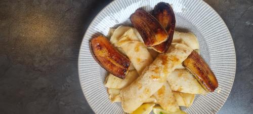 a white plate of food with potatoes and sausages at Mosswood Bed & Breakfast in Graskop
