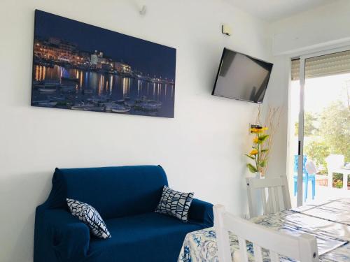 a living room with a blue couch and a tv at Villa Mirante - Maruggio in Maruggio