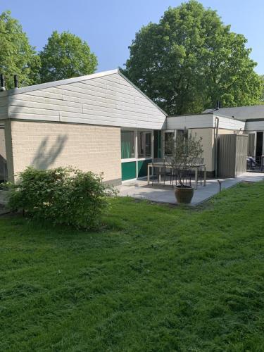 a building with a picnic table in front of a yard at Vakantiehuis ontdek Zuid - Limburg in Simpelveld