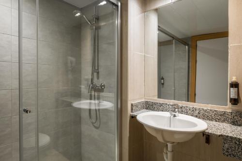 マガルフにあるアパルタメントス ヴィスタソルのバスルーム(ガラス張りのシャワー、シンク付)